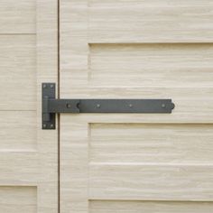 a close up of a wooden door with a metal hinge on the front and side