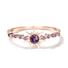 a gold ring with an amethorate and purple stones on the front, set in