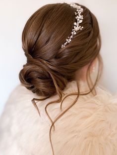 a woman with brown hair wearing a bridal headpiece in her left side view