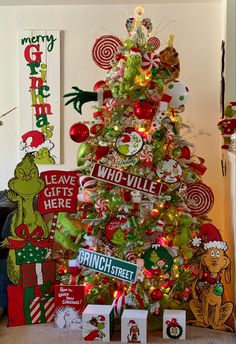 a christmas tree is decorated with candy canes and grin - like signs, including the grin