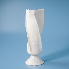 a white vase sitting on top of a blue table