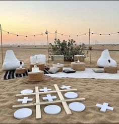 an outdoor seating area is set up in the sand with crosses and baskets on it