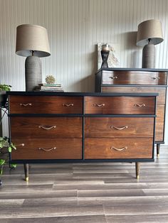 a dresser with two lamps on top of it