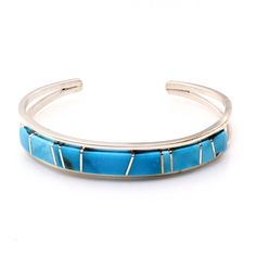 Experience the exquisite craftsmanship of Navaho artist Sam Arviso with this handcrafted Turquoise channel inlay bracelet. Measuring 5 1/4" from tip to tip with a 1" opening, this bracelet is expertly crafted and not easily adjustable. Its sleek 3/8" width and weight of approximately 17.4 grams make it a stunning addition to any jewelry collection. Adjustable Turquoise Bracelet With Polished Finish, Adjustable Turquoise Bracelets With Polished Finish, Adjustable Turquoise Inlay Bracelets, Adjustable Turquoise Cuff Bracelet With Polished Finish, Adjustable Turquoise Bracelet With Inlay, Adjustable Turquoise Polished Cuff Bracelet, Artisan Turquoise Bracelets With Inlay, Artisan Turquoise Bracelet With Inlay, Southwestern Style Blue Inlay Bracelets