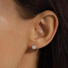 a close up of a person wearing a pair of diamond ear studs on their ears