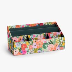 a multicolored floral box with compartments for pens and pencils on a white background