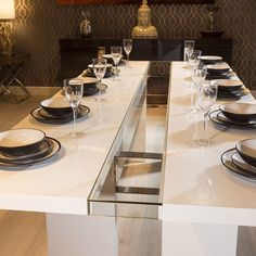 the table is set with black and white plates, silverware, and wine glasses