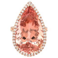 Lovely gemstones set in rose gold, this 16.00 carat mystical Morganite adds a touch of fresh sexiness to this ring. Set in 14K gold, there will be no denying the durability of this ring paired with the everlasting salmon colored beryl. Although cousin to the Emerald, Morganites are very different and are exceptionally clear making this gem a treat to look at. Paired with diamonds upon an intricate gold mesh, this ring will be eternally trendy. LCK20183-MOR #366908 Ring Overview SKU 4601 Center Stone Morganite Side Stones Diamonds Metal Type 14K Rose Gold Metal Weight 5.43 gr Size 6.5 Center Stone Quantity 1 Total Weight 16.00 carats Color Pink Orange Color intensity Strong Shape Pear Clarity Very eye clean Cut Brilliant/step Treatments Heated Dimensions 23.22 x 13.5 x 9.99 mm Diamonds Quan Rose Gold Diamond Ring, 14k Rose Gold Ring, Detailed Ring, Rose Gold Metal, Color Ring, Diamond Sizes, Morganite, Cocktail Rings, Rose Gold Ring