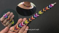 a hand holding a beaded bracelet made with multicolored beads