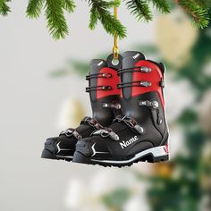 a pair of black and red snow boots hanging from a christmas tree ornament