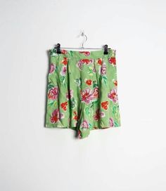 "a vintage pair of high-waisted green and pink floral pattern shorts with buttons all the way up the left side ✿ IMPORTANT INFORMATION: * excellent vintage condition * material: 100% viscose * size: small - please check exact measurements below (they're there for your benefit!) * garment care: machine washable * made in belgium ✿ MEASUREMENTS (taken while item is lying flat, some measurements will need to be doubled): * waist: 14\" (36cm) * hips: 25\" (64cm) * front rise: 14.5\" (37cm) * back ri Green Knee-length Shorts For Vacation, Retro Floral Print Short Bottoms, Green Floral Print Cotton Bottoms, Green Cotton Bottoms With Floral Print, High Waist Green Shorts For Summer, Vintage Floral Print Bottoms For Spring, Green Summer Pajama Shorts, Retro Floral Print Shorts, Fitted Floral Print Shorts