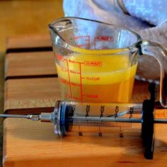 a measuring cup filled with liquid next to a thermometer