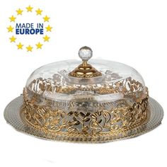 a glass covered dish with gold trimmings and a domed cover on the top