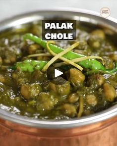 a metal bowl filled with green vegetables and sauce on top of a wooden table next to a text overlay that reads palak chole