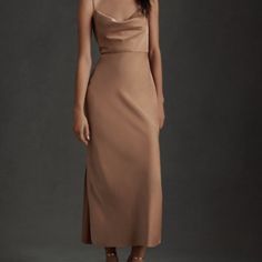 a woman in a tan dress posing for the camera