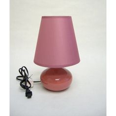 a pink lamp sitting on top of a table next to a plugged in charger