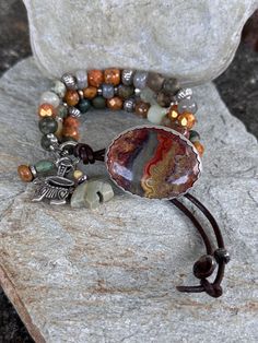 A very cool Desert Jasper cab  set in Sterling is the focal of this Earthy Bracelet.  The photos don't do it justice. It looks like the Desert Sky at Dusk.  I incorporated Green Rhyolite, Labradorite, Very cool Copper enameled Raku beads, Topaz Czech Glass and a plethora of Hill Tribe Silver.  I love the blend of muted desert colors! Hoodoos are a pewter Wild Rabbit and a Silver Leaf Jasper Zuni Bear. All give that Southwestern Cowgirl feel.   Leather loop can be adjusted for a tighter or looser fit. Hill Tribe Silver is made by the Hill Tribe people of Thailand. It is 99% pure Silver, as opposed to sterling silver which is 92.5%. Made by traditional methods, each piece is handmade, and is rolled and hammered with primitive tools. Bohemian Jasper Beaded Bracelets With Natural Stones, Bohemian Jasper Bracelet, Bohemian Jasper Beaded Bracelets For Healing, Bohemian Jasper Round Bead Bracelets, Bohemian Jasper Bracelets As A Gift, Bohemian Hand-wrapped Jasper Jewelry, Bohemian Jasper Bracelets With Gemstone Beads, Handmade Earthy Jasper Bracelets, Handmade Artisan Jasper Bracelets