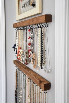 a bunch of necklaces hanging on a wall next to a door with an instagram message