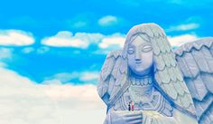 an angel statue in front of a blue sky