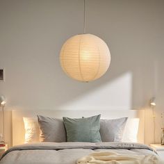 a bedroom with a bed, nightstands and lamps on the ceiling above it is a round light fixture that hangs over the bed