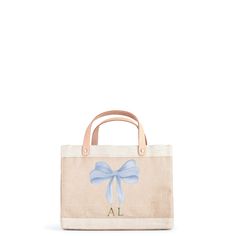 Petite Market Bag in Natural with Powder Blue Bow by Amy Logsdon Handheld Canvas Bag With Handles For Shopping, Handheld Canvas Bag For Shopping, Everyday Handheld Bags With Leather Handles, On-the-go Bucket Bag With Rolled Handles, Everyday Bags With Rolled Handles And Pouch Shape, On-the-go Pouch Bag With Leather Handles, Spring Beige Bags With Rolled Handles, Everyday Pouch Bag With Rolled Handles, On-the-go Double Handle Canvas Bag