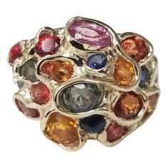 14 karat multicolored sapphire cluster ring, containing 25 round sapphires (orange, yellow, blue, green and lavender) of very fine gem quality weighing 6.43cts. This ring is a size 7 but we will size to fit for free. Luxury Multi-stone Classic Sapphire Ring, Luxury Elegant Cluster Gemstones, Luxury Multi-stone Gold-toned Gemstones, Luxury Multicolor Round Gemstones, Luxury Multicolor Jewels Gemstones, Luxury 22k Gold Multicolor Jewelry, Multicolor Sapphire Multi-stone Ring, Multicolor Multi-stone Sapphire Ring, Multicolor Sapphire Ring In Fine Jewelry Style