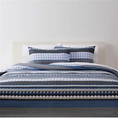 a bed with blue and white bedspread on top of it