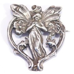 This is such a sweet original Art Nouveau era brooch featuring a whimsical fairy. Measures 2 inches tall by 1 and ⅝ inch wide.  Condition is very good, the front is sterling silver and the back is nickel silver. Marked STERLING TOP in very good condition. Silver Art Nouveau Brooches As Gift, Silver Art Nouveau Brooches For Gifts, Silver Art Nouveau Brooch, Garnet Drop Earrings, Hand Mirrors, Whimsical Fairy, Fairy Jewelry, Sterling Silver Brooch, Hand Mirror