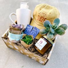 a box filled with assorted items on top of a cement floor next to a hat