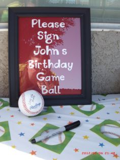 a birthday sign with baseballs and bat on a table