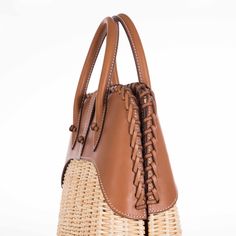 This Hermes Picnic Bolide, crafted in 2017, is an exquisite blend of rustic charm and refined elegance. This unique bag marries the natural beauty of Osier Wicker with the luxurious touch of Fauve Barenia leather, creating an accessory that is both visually stunning and tactilely inviting. The body of the bag is made from finely woven Osier Wicker, evoking the essence of serene summer days and elegant countryside escapades. This natural material adds an element of artisanal craftsmanship and giv Elegant Brown Handwoven Straw Bag, Elegant Handwoven Brown Straw Bag, Elegant Rectangular Leather Straw Bag, Elegant Leather Woven Straw Bag, Elegant Brown Straw Bag With Woven Leather, Elegant Leather Straw Bag With Leather Handles, Elegant Natural Basket Bag, Elegant Natural Color Basket Bag, Elegant Natural Basket-shaped Bag