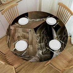 the table is set with white plates and silverware on it's wooden surface