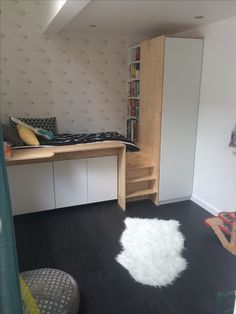 a room with a bed, desk and bookshelf