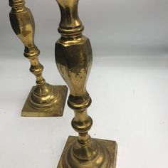 two brass candlesticks are standing next to each other