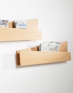 two wooden shelves holding newspapers and magazines