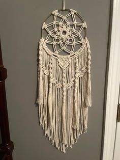 a white dream catcher hanging on the wall