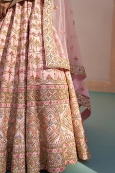 Blush pink lehenga with zardozi embroidery using silken threads, dabka, cutdana and sequins. Comes with embroidered blouse and two embroidered dupattas.
Component: 4
Pattern: Embroidered
Type Of Work: Zardozi, silken threads, dabka, cutdana and sequins
Neckline: Plunged Neck
Sleeve Type: Short
Fabric: Raw Silk
Color: Pink
Other Details: 
Broad leaf shaped neckline
Back cut-out with tassel tie-up
Semi-sheer dupattas with embroidery
Occasion: Bride, Wedding - Aza Fashions Pink Sharara With Dori Work For Reception, Pink Choli With Resham Embroidery In Traditional Drape, Pink Choli With Resham Embroidery And Traditional Drape, Anarkali Pink Embroidered Choli, Pink Salwar Kameez With Zari Work For Reception, Pink Resham Embroidery Dupatta For Reception, Pink Choli With Resham Embroidery, Pink Traditional Wear With Intricate Embroidery, Pink Designer Floor-length Saree