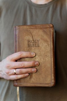 a person holding a bible in their hands