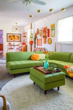 a living room with green couches and white rugs on top of the floor