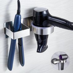 the hair dryer is hanging on the wall next to two attachments that are connected to each other