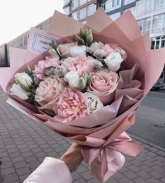 a person holding a bouquet of flowers on the street