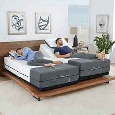 two people laying on top of mattresses in a living room next to each other