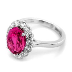 an oval shaped ruby and diamond ring on a white background with the center stone surrounded by diamonds