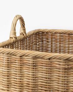 a wicker basket with handles on a white background, showing the handle and sides