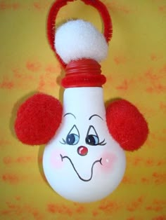 a red and white light bulb with a clown face painted on it's side