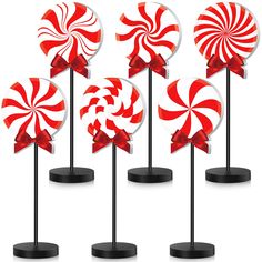 four red and white lollipops on black stands