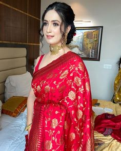 a woman in a red sari standing on a bed