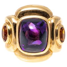 14k yellow gold ring. This impactful ring has a rectangular sugarloaf cabochon cut dark purple color amethyst center, bezel set and flanked by two oval faceted, dark orange color citrines, approximately 0.18 TCW, also bezel into a chunky, contemporary rectangular profile mounting. Marks: 14k Dimensions: 13/16" across the top x 11/16" wide Weight: 9.3 gross dwt Ring Size: 6.5 Dark Orange Color, Amethyst Cocktail Ring, Dark Purple Color, Amethyst And Citrine, Yellow Gold Cocktail Ring, Amethyst And Diamond Ring, Gold Cocktail Ring, Citrine Ring, Dark Orange