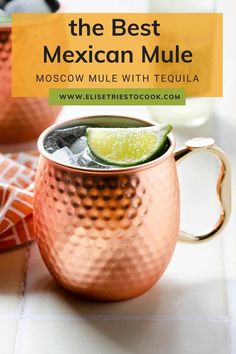 two copper mugs with lime slices on the rim, one filled with ice and one empty