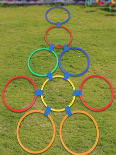 a long row of rings sitting on top of a lush green field next to a park